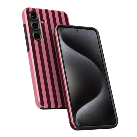 a pink and black striped phone case with a black smartphone placed on top of it.