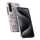 a smartphone case with a floral pattern in shades of purple and green. The case is designed to protect the phone and add a decorative touch.