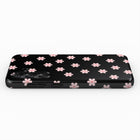 A black phone case with a pattern of pink flowers on it.