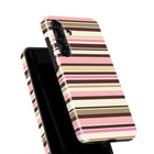 a phone case with a striped pattern in shades of pink, brown, and beige.