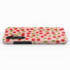 a pink phone case with a repeating pattern of red cherries and green leaves.