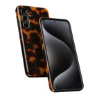 a smartphone with a tortoiseshell pattern on its back cover and a black screen.