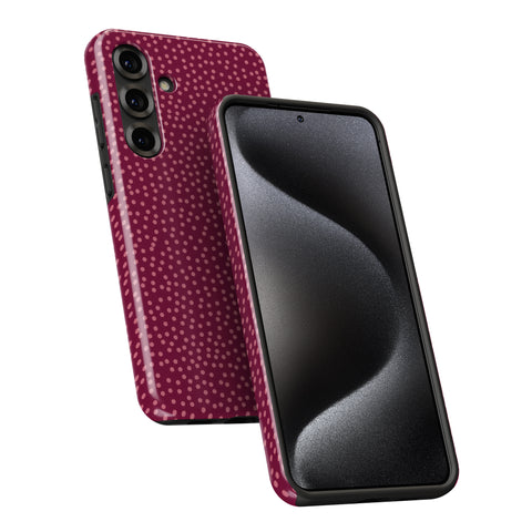 a smartphone with a pink dotted pattern on its back cover and a black screen.