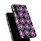 a phone case with a pink heart pattern on a black background.