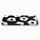 A black and white phone case with a repeating pattern of white flowers on a black background.