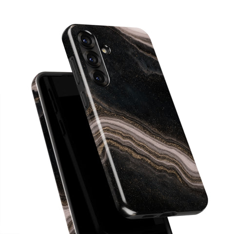a black smartphone case with a marble-like pattern in shades of black, gold, and white.
