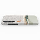 a phone case with a dotted pattern and a moon-like design on it.