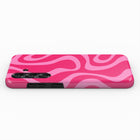 A pink and white swirly pattern on a phone case.