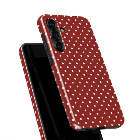 a red phone case with white polka dots.