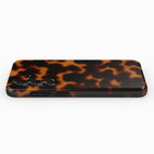 A tortoiseshell-patterned phone case with three camera lenses visible.