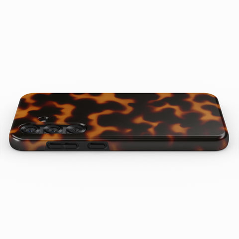 A tortoiseshell-patterned phone case with three camera lenses visible.