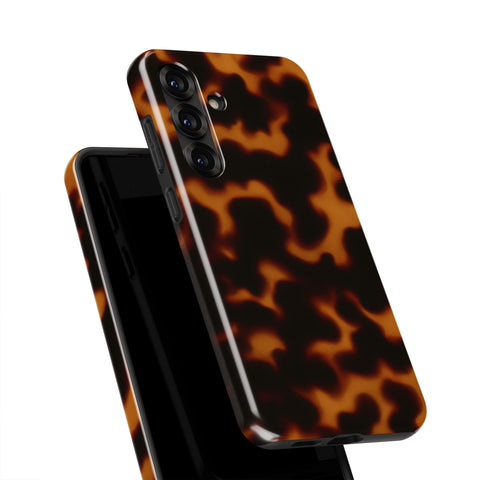 A close-up view of a tortoiseshell-patterned phone case, with the back of the phone facing upwards.