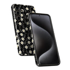 a smartphone with a black floral pattern on its back cover and a black screen.