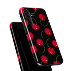 a black phone case with a repeating pattern of red cherries on a black background.
