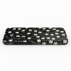 A black phone case with a white floral pattern on it.