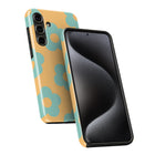 a smartphone case with a floral pattern in yellow and blue colors. The case is designed to protect and showcase the phone's screen.