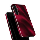 A close-up view of a red smartphone case with a shiny, reflective surface.