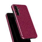 a smartphone case with a maroon polka dot pattern.