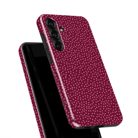 a smartphone case with a maroon polka dot pattern.
