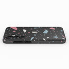 a smartphone case with a black background and a colorful, speckled pattern of small, multicolored shapes.