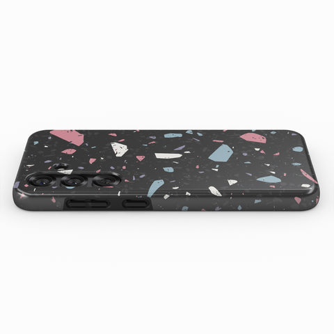 a smartphone case with a black background and a colorful, speckled pattern of small, multicolored shapes.