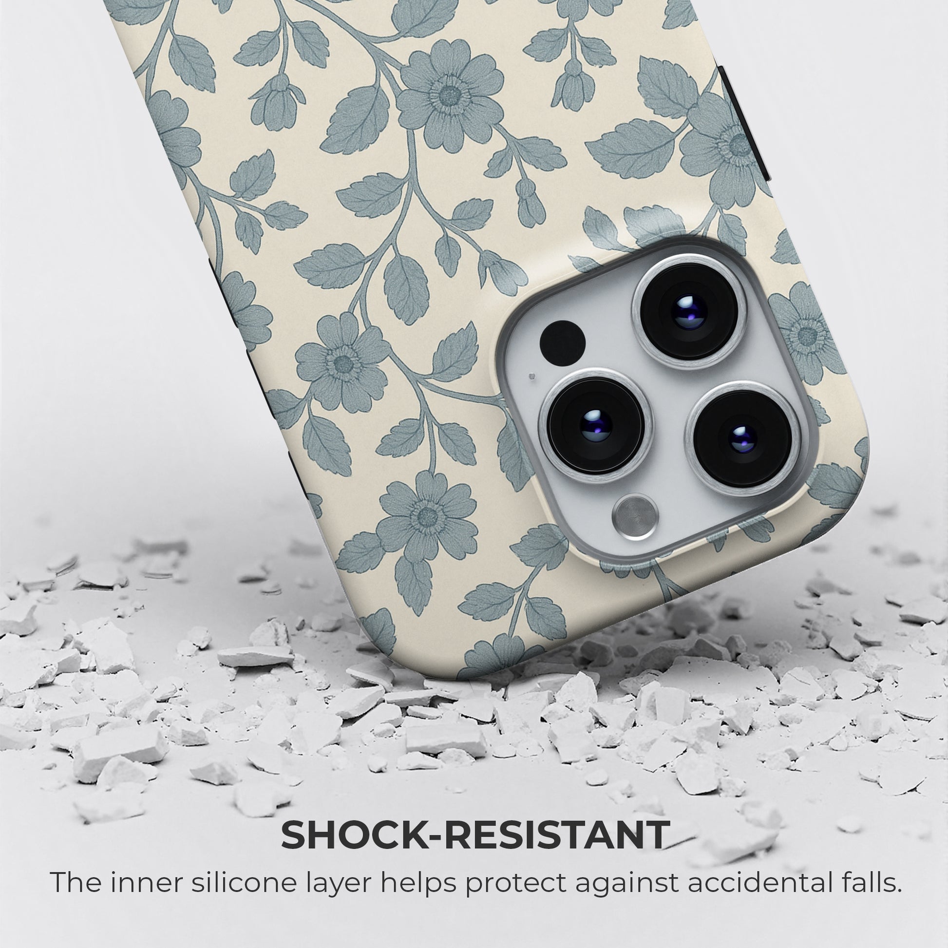 Shock-resistant blue floral and leaf pattern iPhone tough case on cream background, with silicone layer for drop protection by HaloCovers