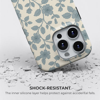 Shock-resistant blue floral and leaf pattern iPhone tough case on cream background, with silicone layer for drop protection by HaloCovers